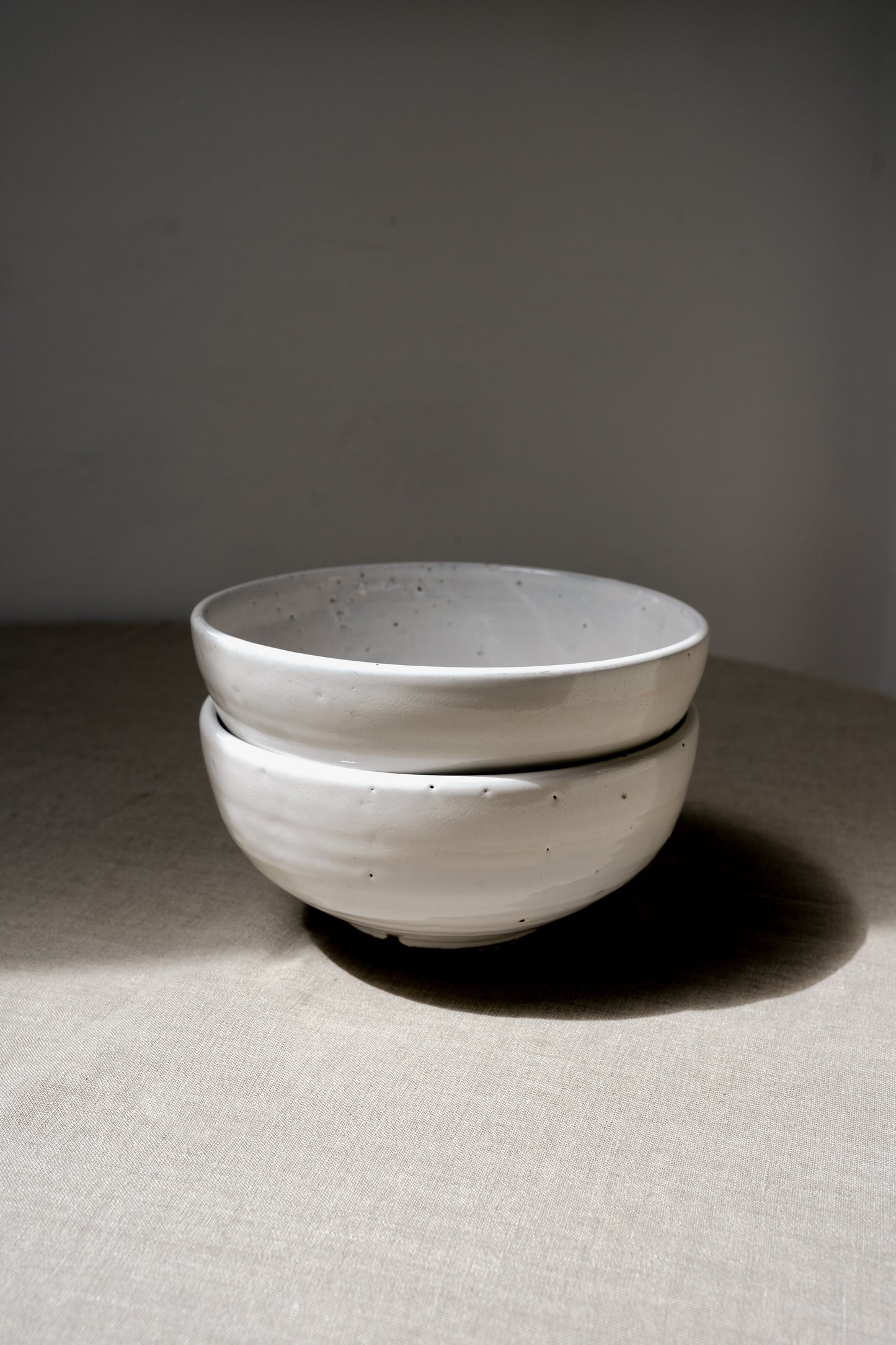 two handmade earthenware white bowls in a pile