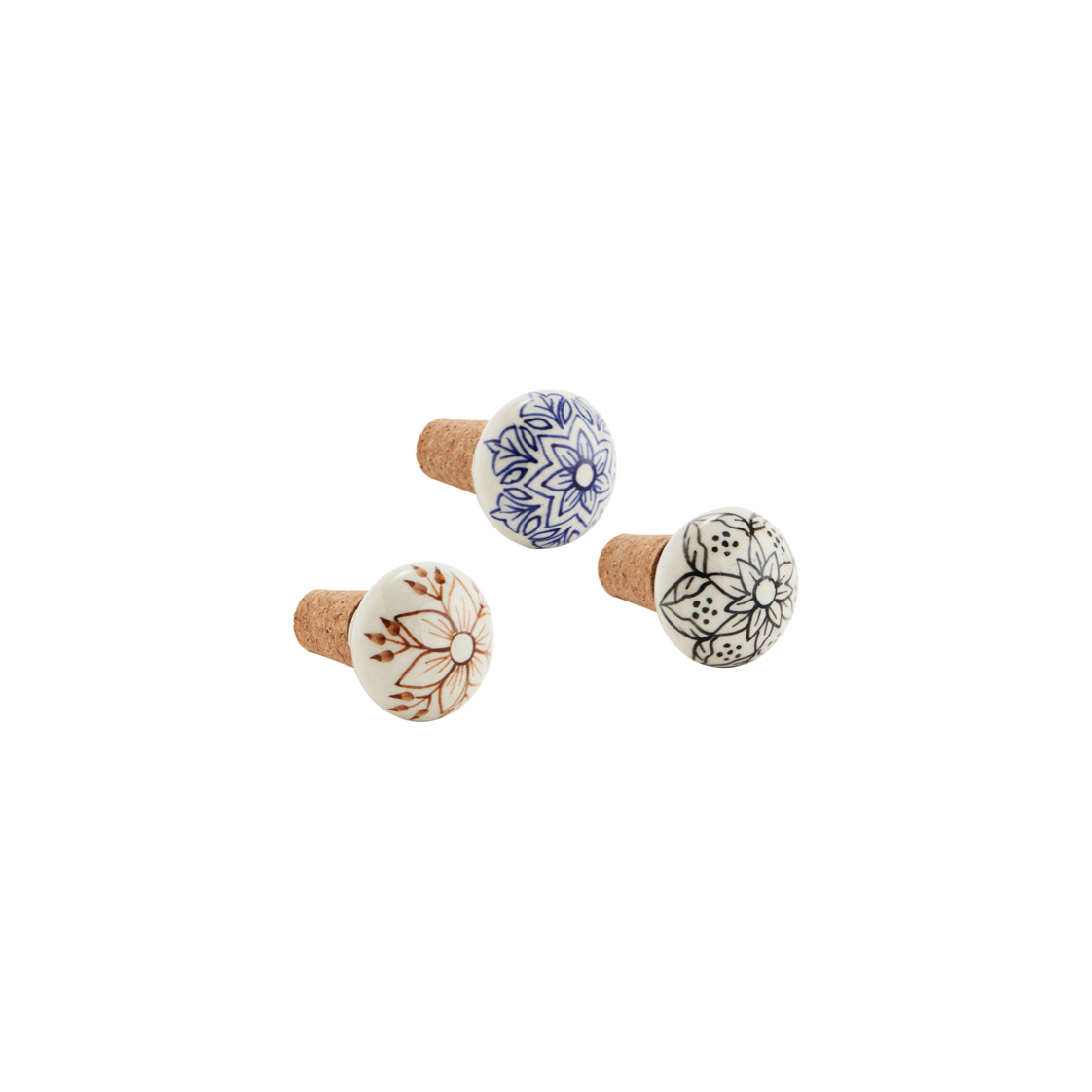 Three bottle stoppers, each ceramic with a cork stopper, all in off white, with floral designs hand painted on the top in black, blue or brown