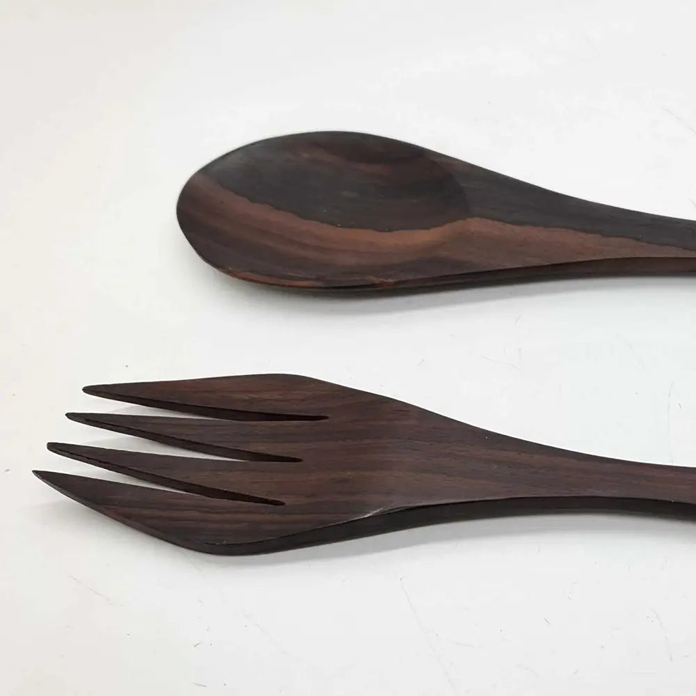 close up of a dark wood salad spoon and salad fork