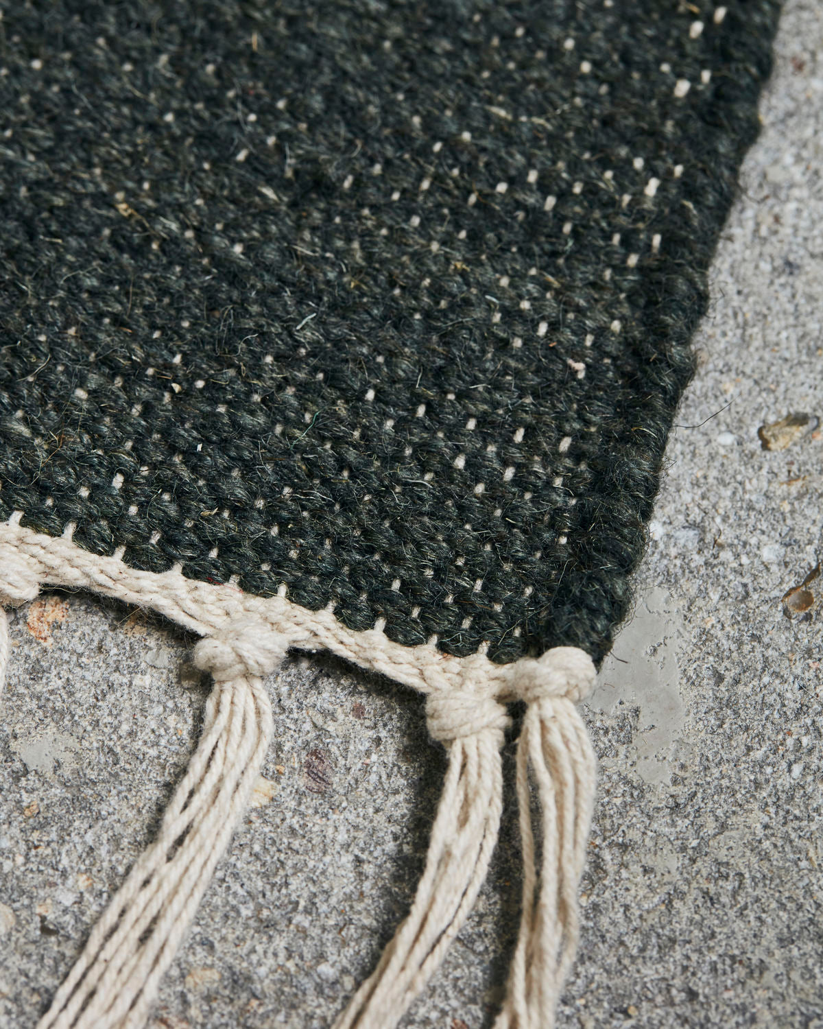 close up of green texture on wool and cotton rug