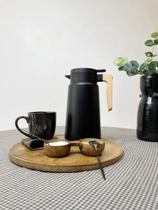 check table cloth with black coffee jug, black mug and black vase with foliage