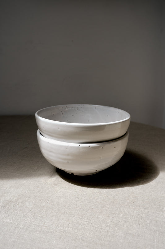 two handmade earthenware white bowls in a pile