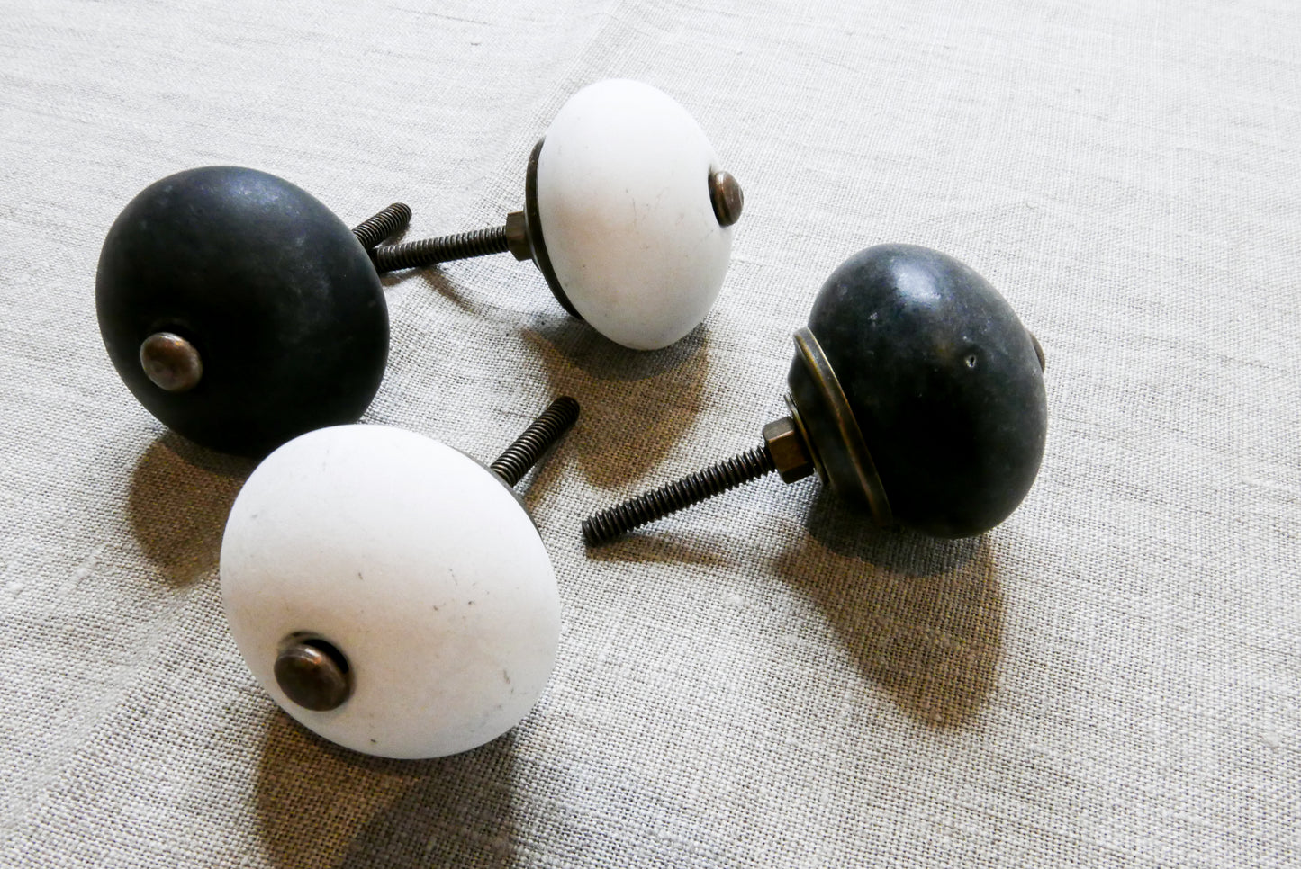 two white and two black stoneware doorhandles / doorknobs