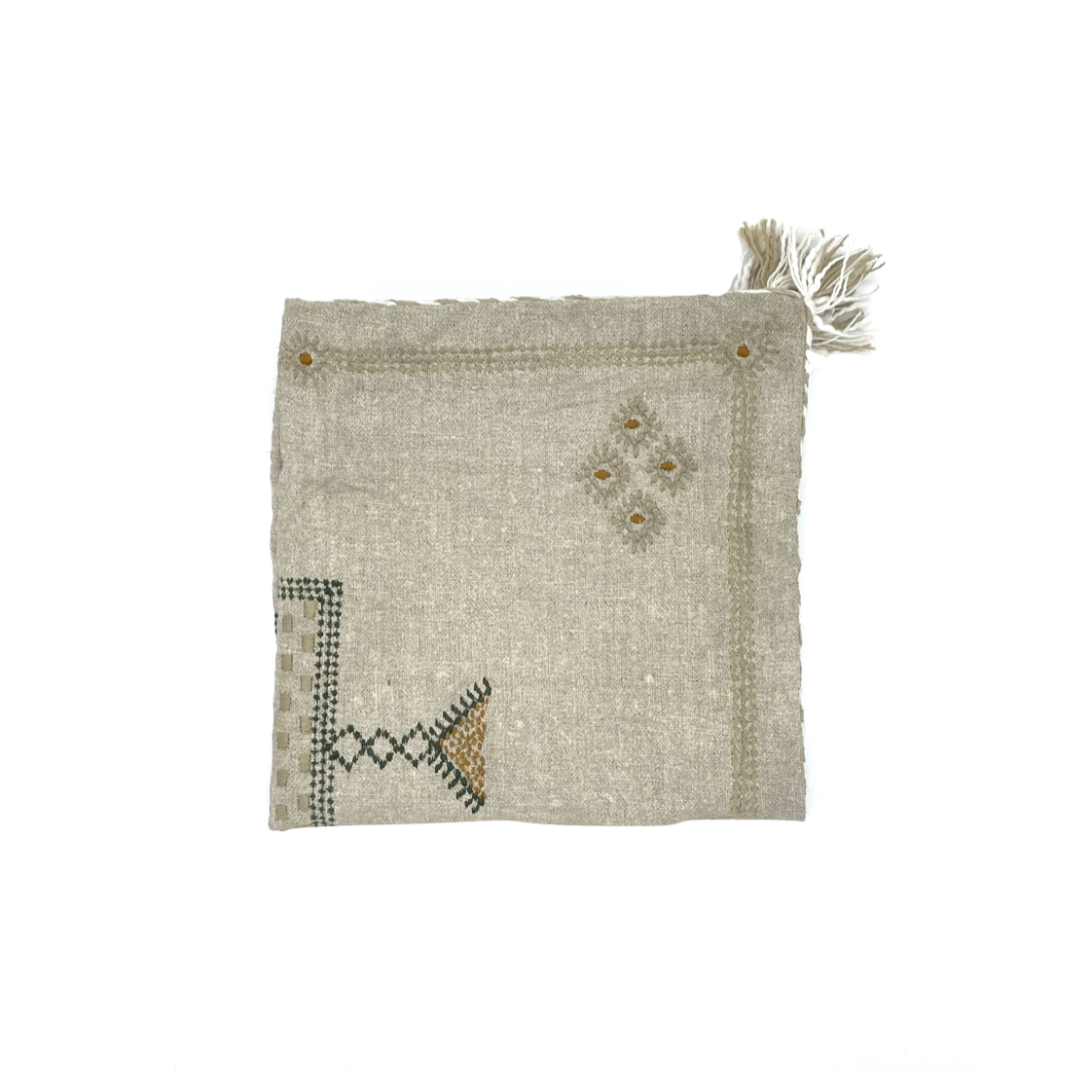 neutral coloured linen embroidered cushion cover with tassels folded in quarters