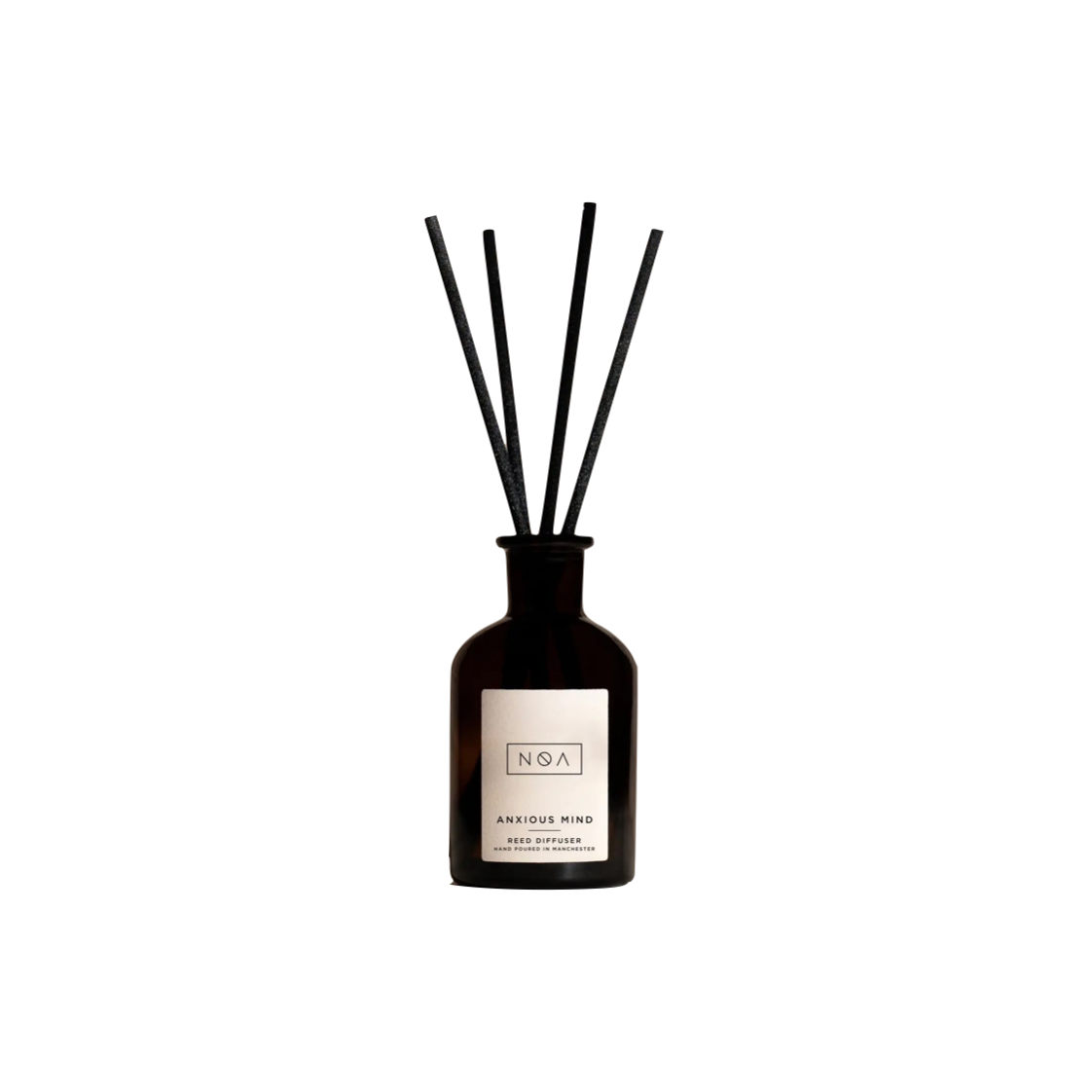 reed diffuser in a black bottle with a white label and four black reeds