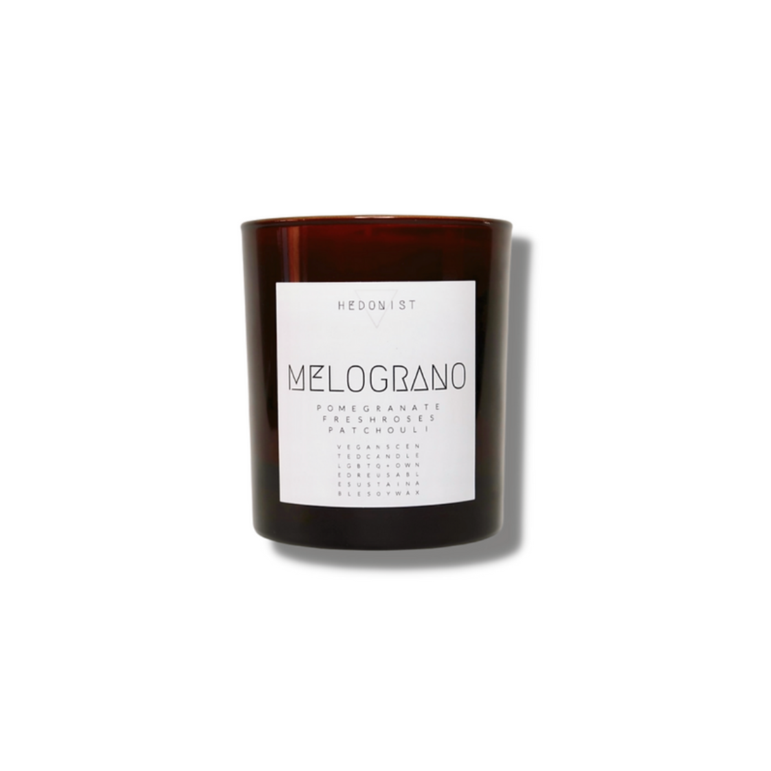 candle in brown glass jar with white label and simple text with the name Melograno