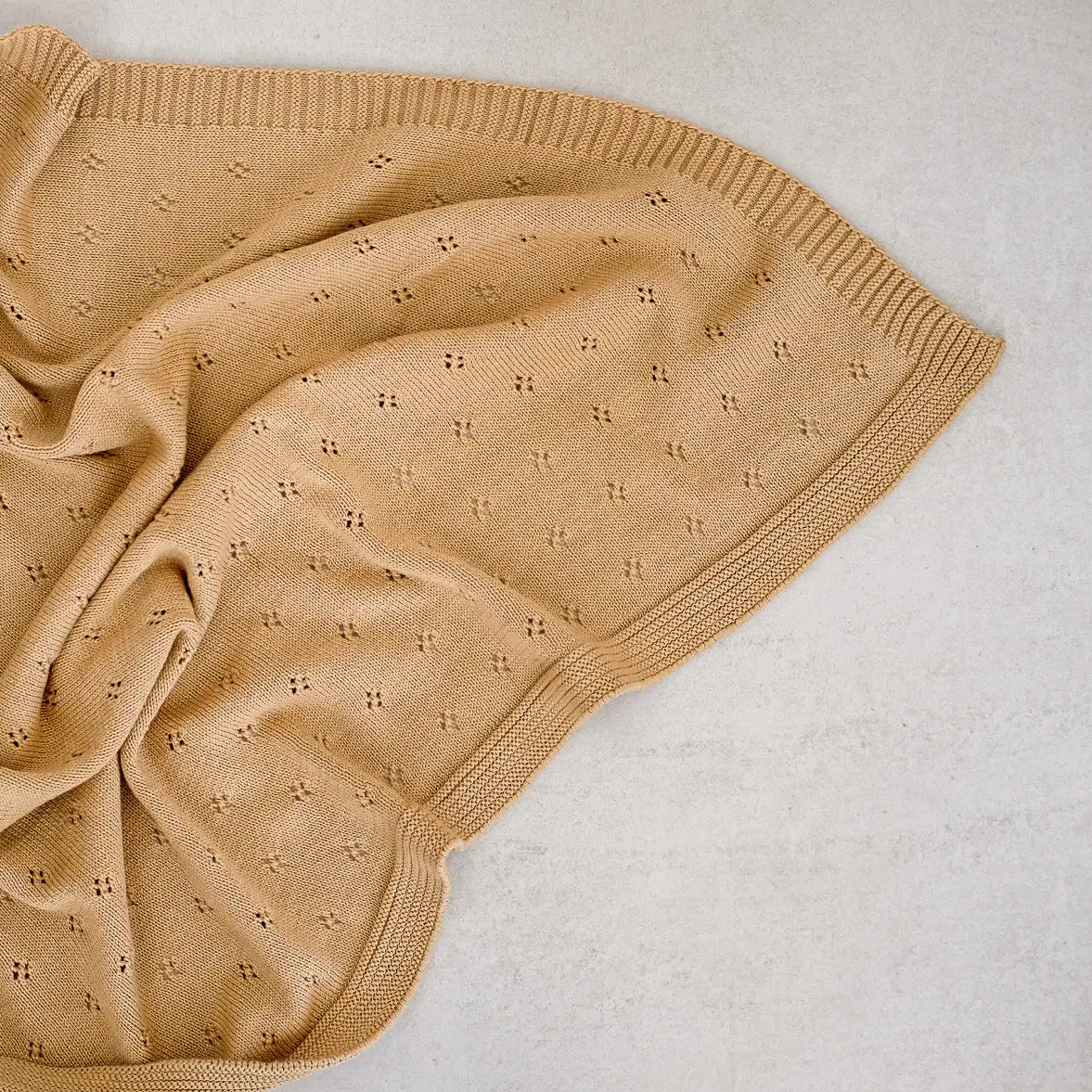 close up of a knitted cotton blanket in ochre