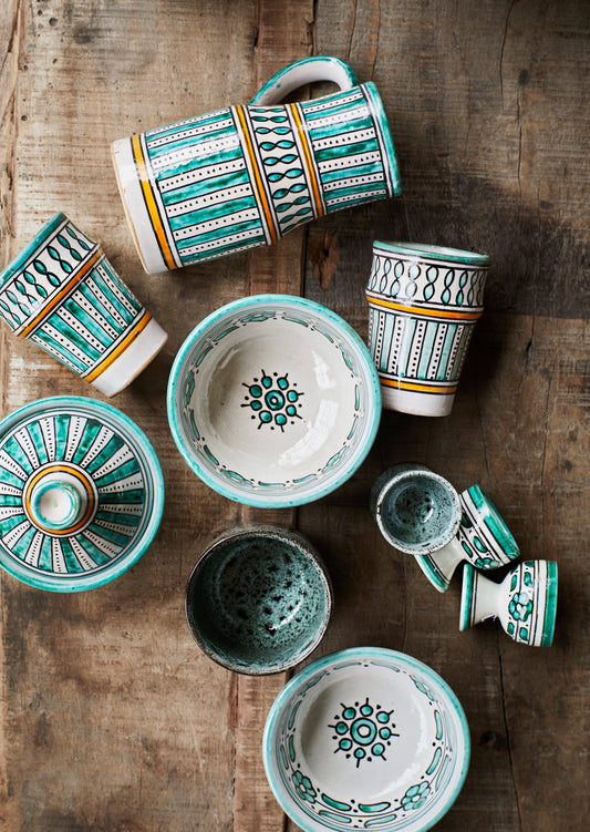collection of handmade jugs, bowls, cups and egg cups, all hand painted in teal, white and orange